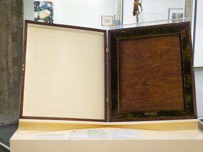 View of a display case with green velvet liner as installed in the gallery